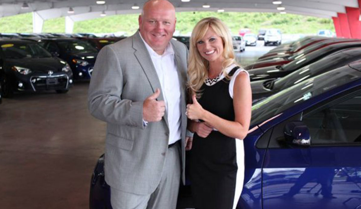 A man and woman give a thumbs-up sign at an auto shoot.