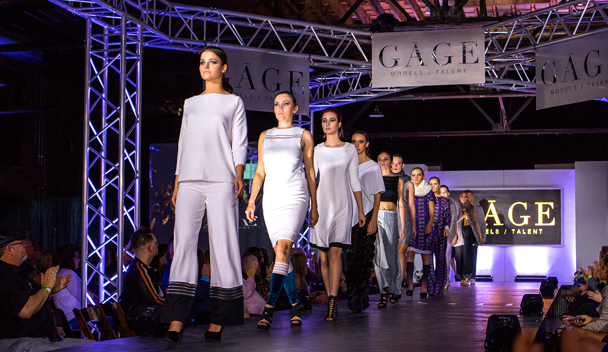 Several models walk along the runway during a show.