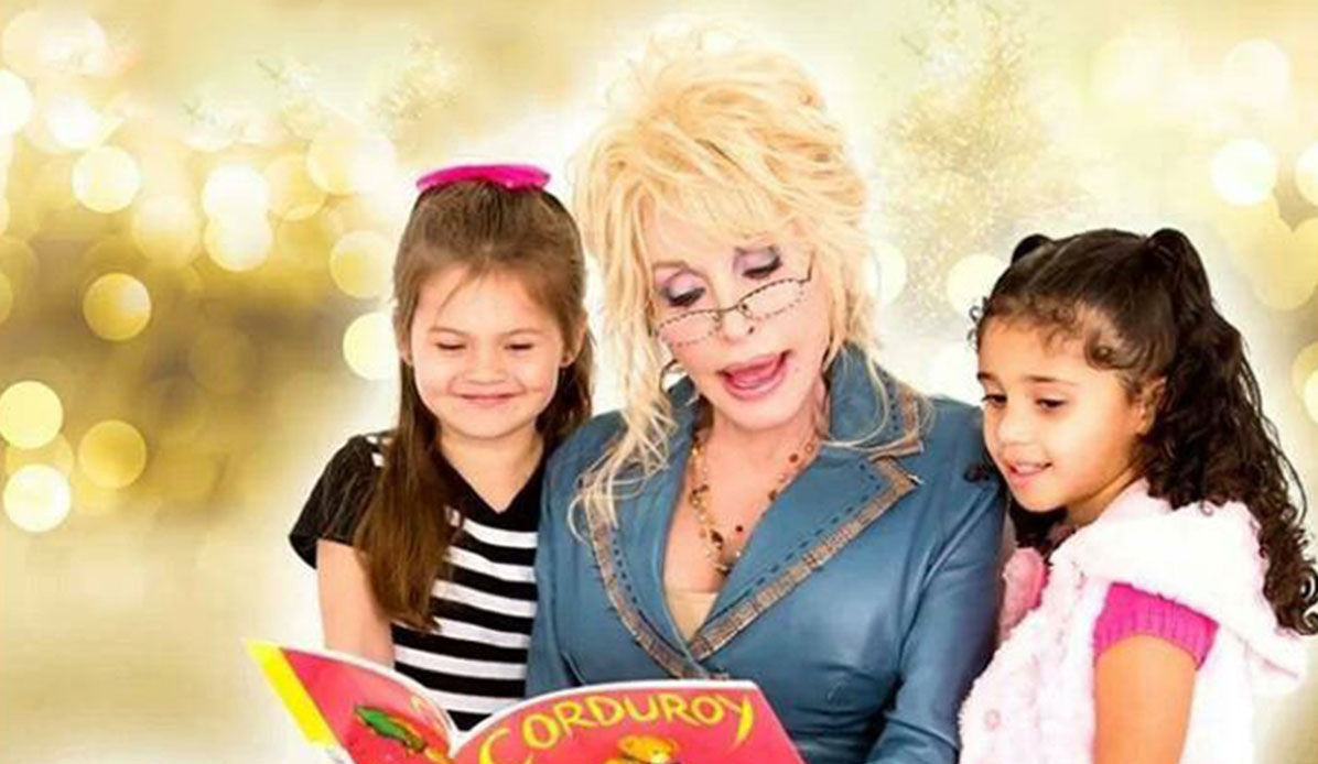 Dolly Parton reads a book to two children.
